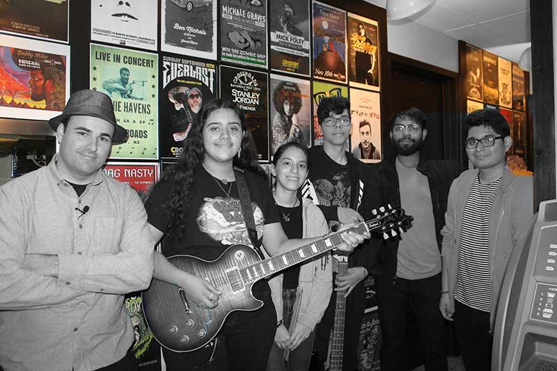 Teens playing bass after completing bass guitar lessons program